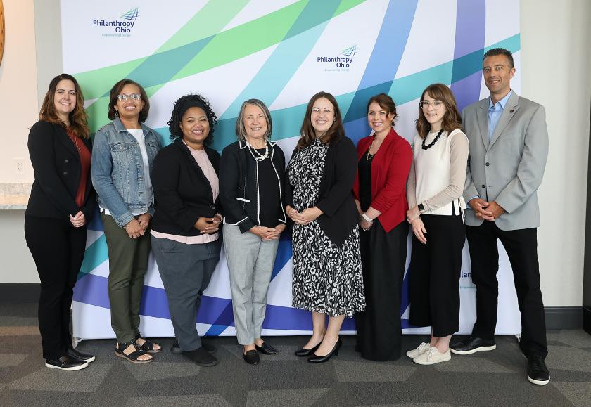 group photo of staff lined up in front of banner 